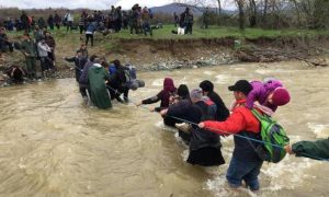 Συγκλονιστικές εικόνες: Πρόσφυγες περνούν χέρι – χέρι ποτάμι στην Ειδομένη
